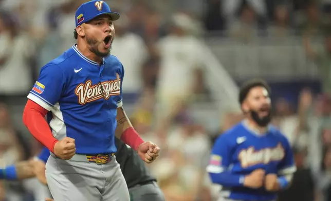 Venezuela catcher William Contreras cheers as Luis Arraez hits a single during the seventh inning of a World Baseball Classic semifinal game against Italy, Monday, March 16, 2026, in Miami. (AP Photo/Rebecca Blackwell)