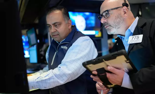 Federico DeMarco, right, and Dilip Patel work on the floor at the New York Stock Exchange in New York, Wednesday, March 25, 2026. (AP Photo/Seth Wenig)