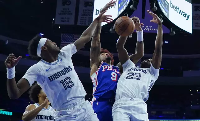 Philadelphia 76ers' Kelly Oubre Jr. (9), Memphis Grizzlies' Olivier-Maxence Prosper (18) and Cedric Coward battle for the ball during the first half of an NBA basketball game, Tuesday, March 10, 2026, in Philadelphia. (AP Photo/Matt Rourke)