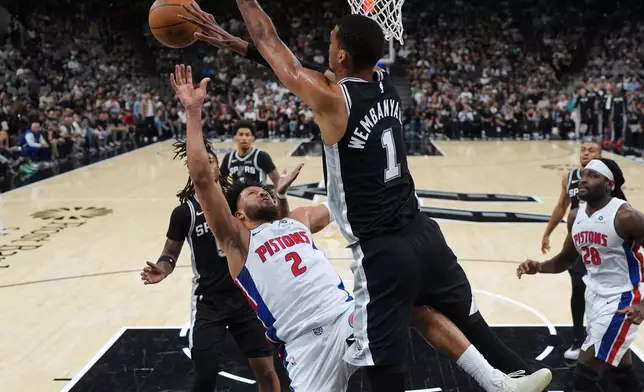 Detroit Pistons guard Cade Cunningham (2) is blocked by San Antonio Spurs forward Victor Wembanyama (1) during the first half of an NBA basketball game in San Antonio, Thursday, March 5, 2026. (AP Photo/Eric Gay)