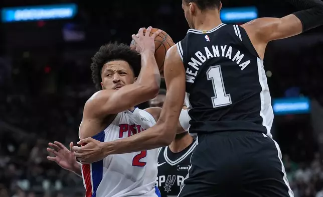 Detroit Pistons guard Cade Cunningham (2) drives against San Antonio Spurs forward Victor Wembanyama (1) during the first half of an NBA basketball game in San Antonio, Thursday, March 5, 2026. (AP Photo/Eric Gay)