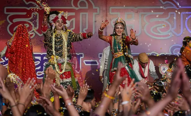 Artists dressed as the Hindu deities Lord Krishna and Radha throw flower petals during Holi festival celebrations at the Shri Krishna Janmabhoomi Temple complex in Mathura, India, on Feb. 27, 2026. (AP Photo/Manish Swarup)