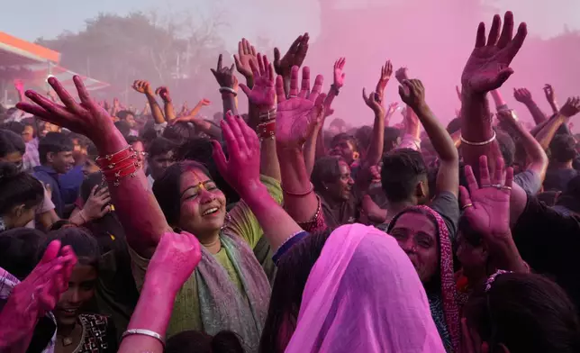 Devotees dance and sing during Holi festival celebrations as colored water is sprayed from above at the Shri Krishna Janmabhoomi Temple complex in Mathura, India, on Feb. 27, 2026. (AP Photo/Manish Swarup)