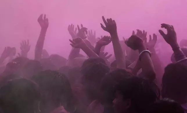 Revelers dance under colored water and powder sprayed from above at the Shri Krishna Janmabhoomi Temple complex during Holi festival celebrations in Mathura, India, on Feb. 27, 2026. (AP Photo/Manish Swarup)