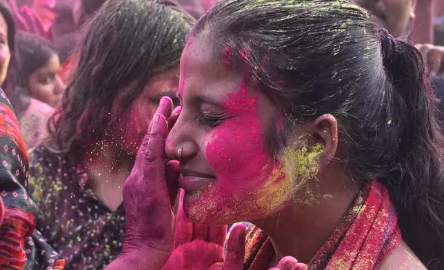 Devotees smear each other with gulal, or colored powder at the Shri Krishna Janmabhoomi Temple complex during Holi festival celebrations in Mathura, India, on Feb. 27, 2026. (AP Photo/Manish Swarup)