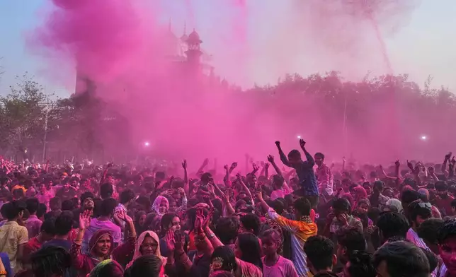 Revelers dance under colored water and powder sprayed from above at the Shri Krishna Janmabhoomi Temple complex during Holi festival celebrations in Mathura, India, on Feb. 27, 2026. (AP Photo/Manish Swarup)