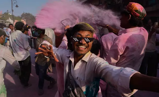Revelers dance in a street during a procession celebrating the Holi festival in Mathura, India, on Feb. 27, 2026. (AP Photo/Manish Swarup)