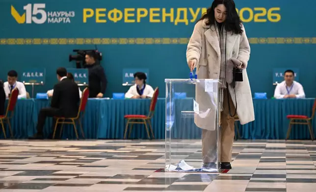 In this photo released by Kazakhstan's President Press Office, a woman casts her ballot at a polling station during a referendum on a new constitution, in Astana, Kazakhstan, Sunday, March 15, 2026. (Kazakhstan's President Press Office via AP)
