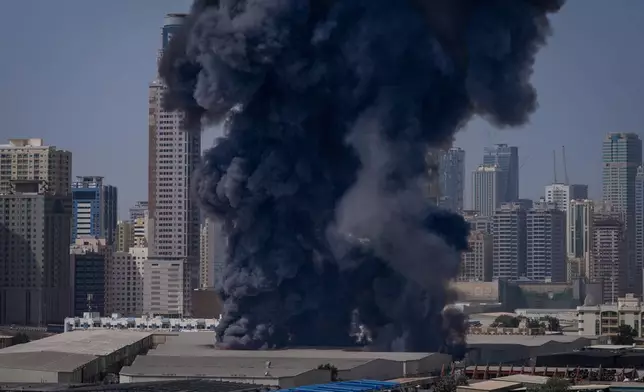FILE - A black plume of smoke rises from a warehouse in the industrial area of Sharjah City following reports of Iranian strikes in Dubai, United Arab Emirates, on March 1, 2026. (AP Photo/Altaf Qadri, File)
