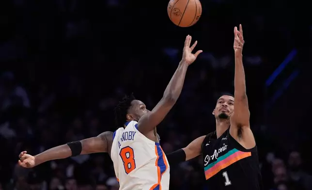New York Knicks' Og Anunoby, left, blocks a pass headed for San Antonio Spurs' Victor Wembanyama during the first half of an NBA basketball game Sunday, March 1, 2026, in New York. (AP Photo/Seth Wenig)