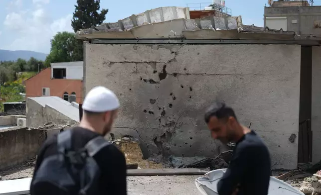 Residents inspect a damaged house following an Iranian missile strike in Shefaram Israel, Monday, March 30, 2026. (AP Photo/Ariel Schalit)