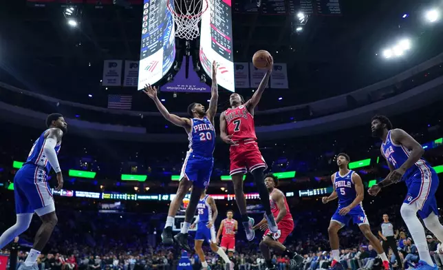 Chicago Bulls' Rob Dillingham, right, goes up for a shot against Philadelphia 76ers' Cameron Payne during the first half of an NBA basketball game Wednesday, March 25, 2026, in Philadelphia. (AP Photo/Matt Slocum)