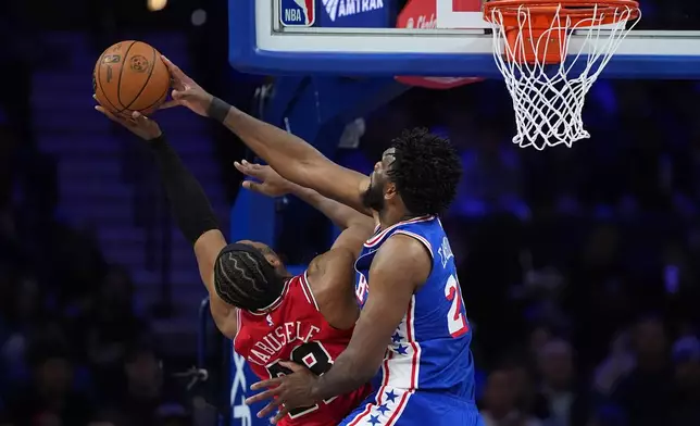 Philadelphia 76ers' Joel Embiid, right, blocks a shot by Chicago Bulls' Guerschon Yabusele during the first half of an NBA basketball game Wednesday, March 25, 2026, in Philadelphia. (AP Photo/Matt Slocum)