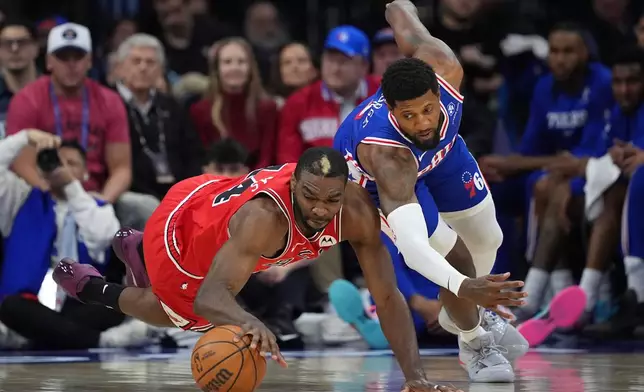 Chicago Bulls' Patrick Williams, left, and Philadelphia 76ers' Paul George chase a loose ball during the first half of an NBA basketball game Wednesday, March 25, 2026, in Philadelphia. (AP Photo/Matt Slocum)
