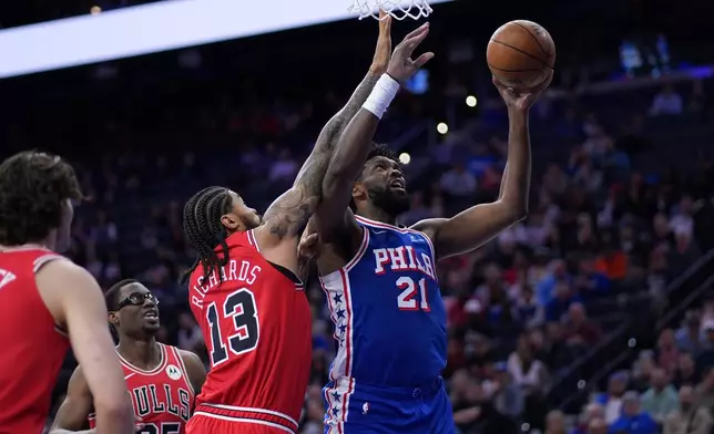 Philadelphia 76ers' Joel Embiid (21) goes up for a shot against Chicago Bulls' Nick Richards (13) during the first half of an NBA basketball game Wednesday, March 25, 2026, in Philadelphia. (AP Photo/Matt Slocum)