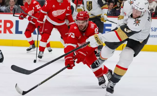 Detroit Red Wings right wing Alex DeBrincat (93) can't block Vegas Golden Knights defenseman Brayden McNabb (3) clearing the puck down the ice during the second period of an NHL hockey game Wednesday, March 4, 2026, in Detroit. (AP Photo/Duane Burleson)