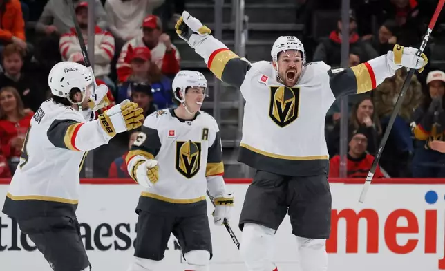 Vegas Golden Knights center Tomas Hertl, right, celebrates with defenseman Rasmus Andersson, left, and right wing Mitch Marner after scoring in overtime to defeat the Detroit Red Wings in an NHL hockey game, Wednesday, March 4, 2026, in Detroit. (AP Photo/Duane Burleson)