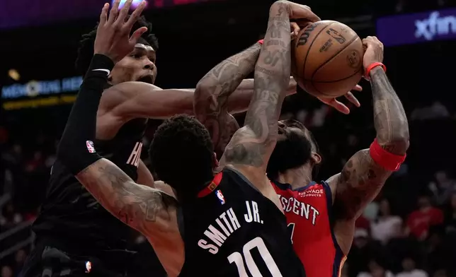 Houston Rockets guard Amen Thompson (1) and forward Jabari Smith Jr. (10) defend against New Orleans Pelicans guard Saddiq Bey during the first half of an NBA basketball game in Houston, Friday, March 13, 2026. (AP Photo/Ashley Landis)