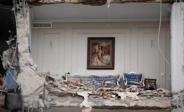 Rubble covers the furniture of a destroyed living room in a residential building hit in an earlier U.S.-Israeli strike in Tehran, Iran, Monday, March 23, 2026. (AP Photo/Vahid Salemi)
