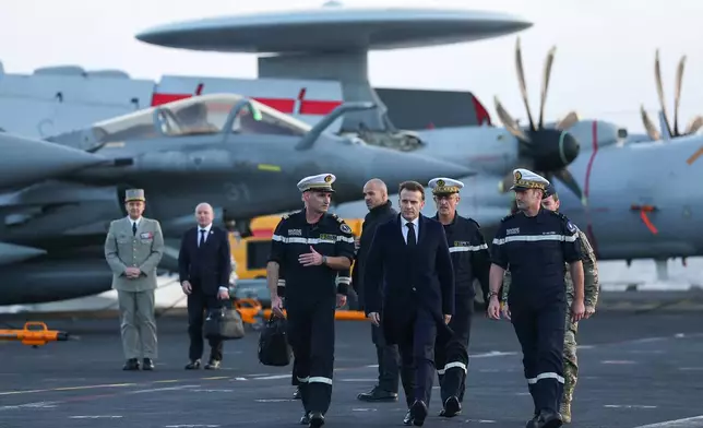 French President Emmanuel Macron, center right, visits the French aircraft carrier Charles de Gaulle, during his visit to Cyprus, Monday March 9, 2026. (Gonzalo Fuentes/Pool Photo via AP)