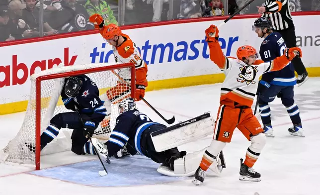 Anaheim Ducks' Tim Washe, front right, celebrates his goal on Winnipeg Jets goaltender Connor Hellebuyck (37) as Haydn Fleury (24) falls into the net during the second period their NHL hockey game, in Winnipeg, Manitoba, Tuesday March 10, 2026. (Fred Greenslade/The Canadian Press via AP)