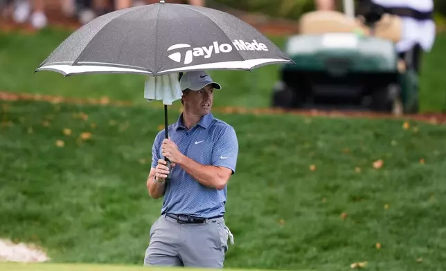 Rory McIlroy of Northern Ireland stands under an umbrella on the ninth fairway during the first round of The Players Championship golf tournament Thursday, March 12, 2026, in Ponte Bedra Beach, Fla. (AP Photo/Gerald Herbert)