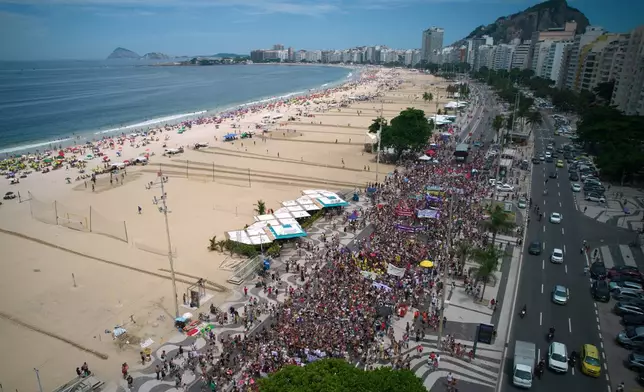 People march marking International Women's Day on Copacabana beach, in Rio de Janeiro, Sunday, March 8, 2026. (AP Photo/Silvia Izquierdo)