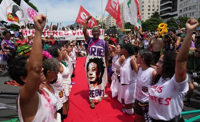 Women perform during a march marking International Women's Day on Copacabana beach, in Rio de Janeiro, Sunday, March 8, 2026. (AP Photo/Silvia Izquierdo)