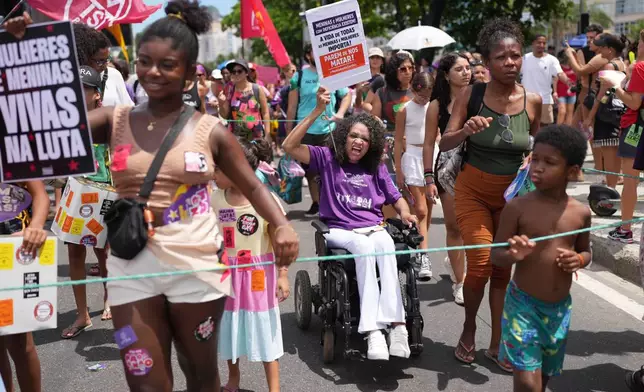 People march marking International Women's Day on Copacabana beach, in Rio de Janeiro, Sunday, March 8, 2026. (AP Photo/Silvia Izquierdo)