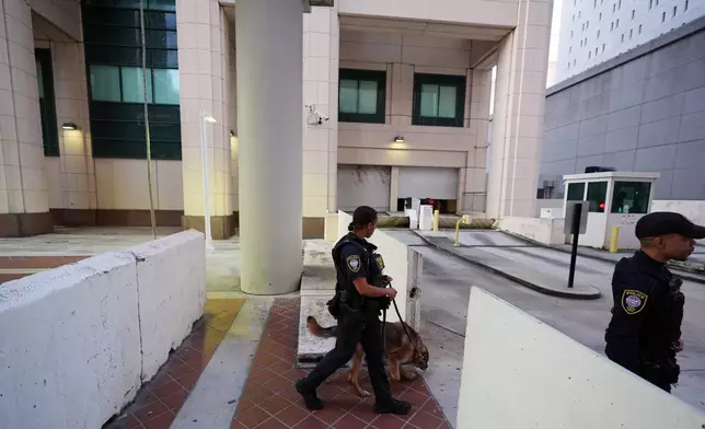 Police with a canine check outside the James Lawrence King Federal Building, where Secretary of State Marco was expected to testify in the trial of his former roommate David Rivera, Tuesday, March 24, 2026, in Miami. (AP Photo/Rebecca Blackwell)