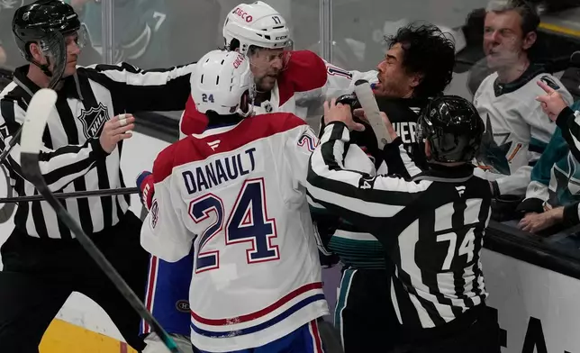 Referees try to separate Montréal Canadiens right wing Josh Anderson, middle left, and center Phillip Danault (24) from San Jose Sharks left wing Kiefer Sherwood, middle right, during the third period of an NHL hockey game in San Jose, Calif., Tuesday, March 3, 2026. (AP Photo/Jeff Chiu)