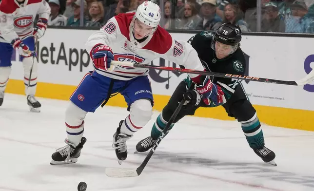 Montréal Canadiens defenseman Lane Hutson, left, skates toward the puck against San Jose Sharks left wing William Eklund during the first period of an NHL hockey game in San Jose, Calif., Tuesday, March 3, 2026. (AP Photo/Jeff Chiu)