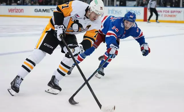 Pittsburgh Penguins' Evgeni Malkin (71) drives past New York Rangers' Gabe Perreault (94) during the overtime period of an NHL hockey game Saturday, Feb. 28, 2026, in New York. (AP Photo/Frank Franklin II)