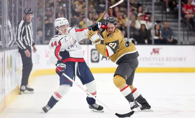 Washington Capitals defenseman Cole Hutson (44) pushes Vegas Golden Knights center Brett Howden (21) while contesting for the puck during the first period of an NHL hockey game Saturday, March 28, 2026, in Las Vegas. (AP Photo/Ian Maule)