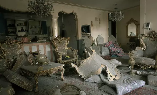 A damaged living room is seen in a house that was affected when a nearby residential building was hit in an overnight strike during the U.S.-Israeli military campaign in Tabriz, East Azerbaijan Province, northwestern Iran, Tuesday, March 24, 2026. (AP Photo/Matin Hashemi)