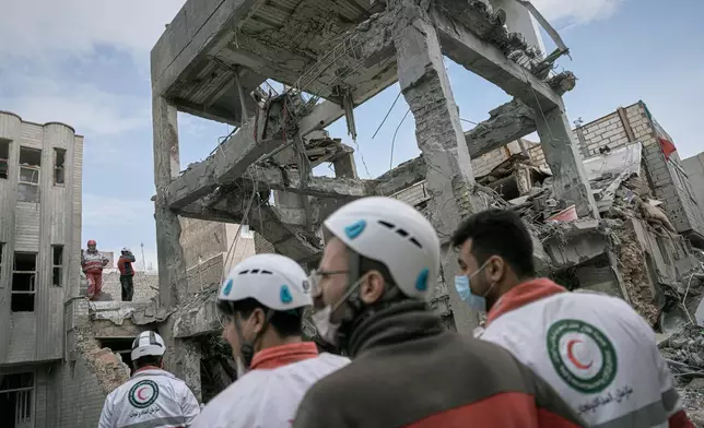 First responders inspect the remains of a residential building hit in an overnight strike during the U.S.-Israeli military campaign in Tabriz, East Azerbaijan Province, northwestern Iran, Tuesday, March 24, 2026. (AP Photo/Matin Hashemi)