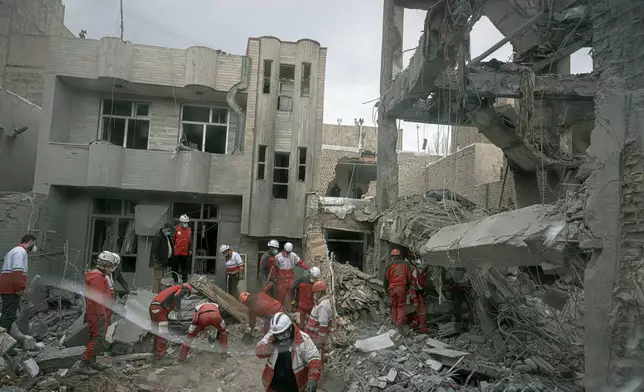 First responders inspect the remains of a residential building hit in an overnight strike during the U.S.-Israeli military campaign in Tabriz, East Azerbaijan Province, northwestern Iran, Tuesday, March 24, 2026. (AP Photo/Matin Hashemi)