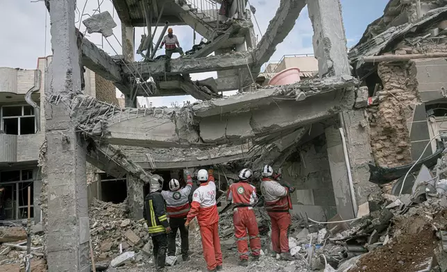 First responders inspect the remains of a residential building hit in an overnight strike during the U.S.-Israeli military campaign in Tabriz, East Azerbaijan Province, northwestern Iran, Tuesday, March 24, 2026. (AP Photo/Matin Hashemi)