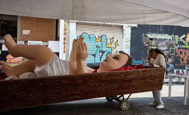 A parishioner crosses herself in front of a giant Baby Jesus in Mexico City, Tuesday, March 10, 2026. (AP Photo/Ginnette Riquelme)
