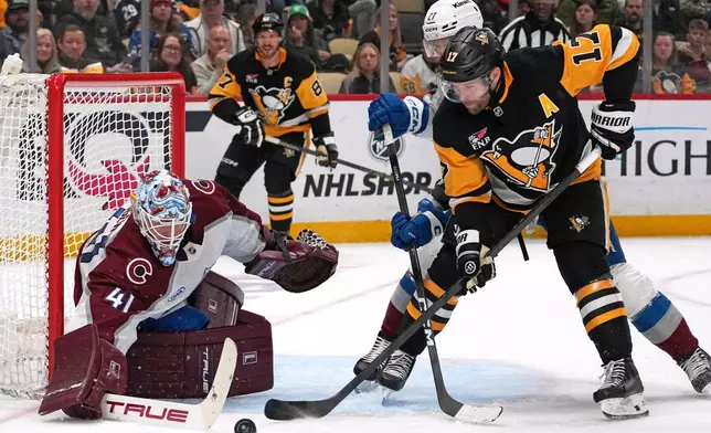 Pittsburgh Penguins' Bryan Rust (17) can't get his stick on the puck in front of Colorado Avalanche goaltender Scott Wedgewood (41) with Brett Kulak (27) defending during the second period of an NHL hockey game in Pittsburgh, Tuesday, March 24, 2026. (AP Photo/Gene J. Puskar)