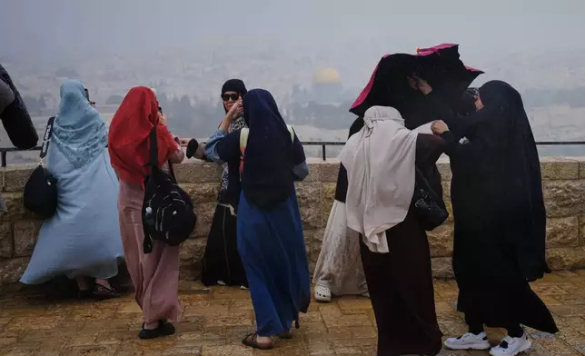 People visit the Mount of Olives, overlooking Jerusalem's Old City Sunday, March 29, 2026. (AP Photo/Mahmoud Illean)