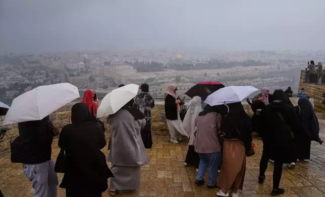 People visit the Mount of Olives, overlooking Jerusalem's Old City Sunday, March 29, 2026. (AP Photo/Mahmoud Illean)