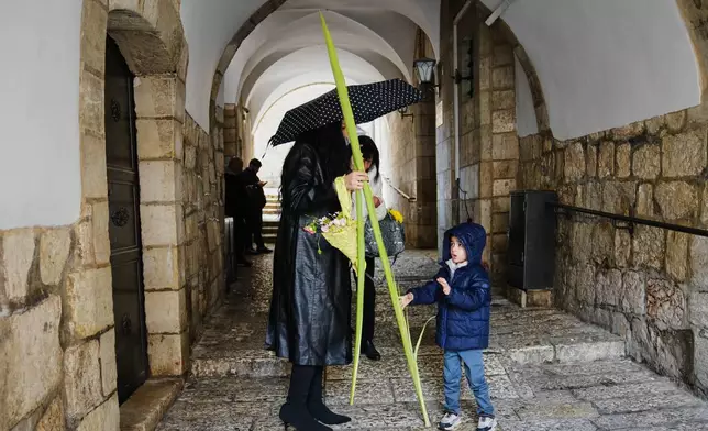 Christians walk with palm branches during Palm Sunday in Jerusalem's Old City, Sunday, March 29, 2026. (AP Photo/Mahmoud Illean)