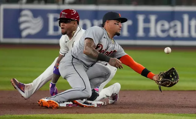 Arizona Diamondbacks' Ketel Marte, left, slides safely into second base as Detroit Tigers shortstop Javier Báez bobbles the ball during a steal attempt in the first inning of an opening-day baseball game Monday, March 30, 2026, in Phoenix. (AP Photo/Darryl Webb)