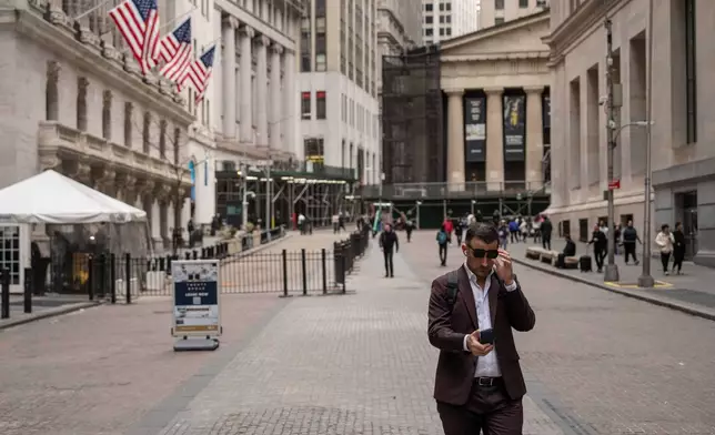 A person walks past the New York Stock Exchange, Friday, March 27, 2026, in New York. (AP Photo/Yuki Iwamura)