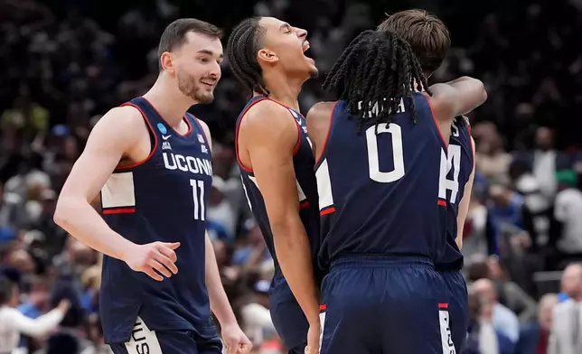 UConn guard Braylon Mullins, right, celebrates his game winning basket with guard Malachi Smith (0) during the second half in the Elite Eight of the NCAA college basketball tournament against Duke, Sunday, March 29, 2026, in Washington. (AP Photo/Stephanie Scarbrough)