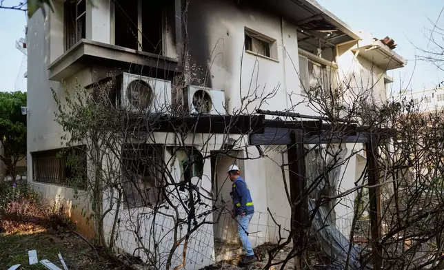 Israeli authorities inspect homes damaged by a projectile launched from Lebanon, in Haniel central Israel, Thursday, March 12, 2026. (AP Photo/Baz Ratner)