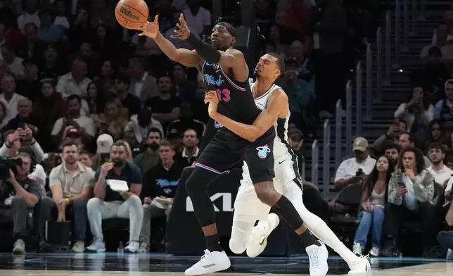 Miami Heat center Bam Adebayo (13) is fouled by San Antonio Spurs forward Victor Wembanyama, right, during the first half of an NBA basketball game, Monday, March 23, 2026, in Miami. (AP Photo/Lynne Sladky)