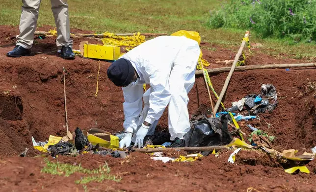 Directorate of Criminal Investigations (DCI) forensic staff inspect the scene of a mass grave where 33 bodies were exhumed at a cemetery in Kericho, Western Kenya Thursday, March 26, 2026. (AP Photo/Andrew Kasuku)