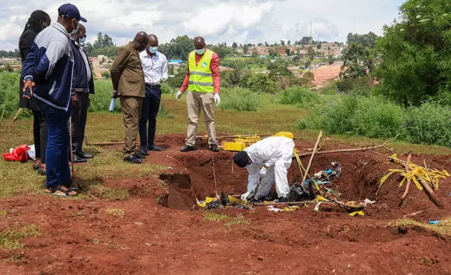 Directorate of Criminal Investigations (DCI) forensic staff inspect the scene of a mass grave where 33 bodies were exhumed at a cemetery in Kericho, Western Kenya Thursday, March 26, 2026. (AP Photo/Andrew Kasuku)